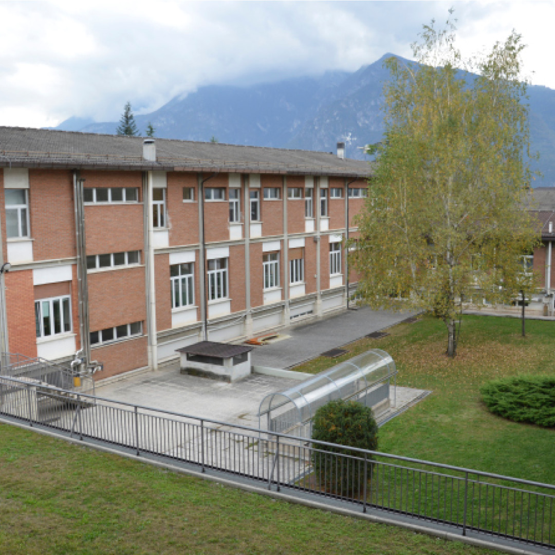 edificio Povo 0 con montagne sullo sfondo e prato