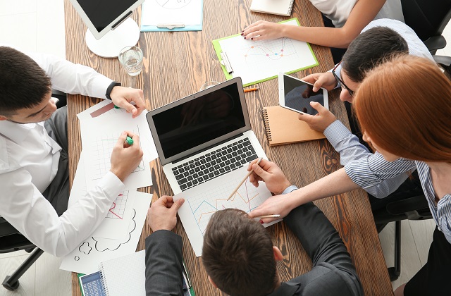 people working around a table with computers