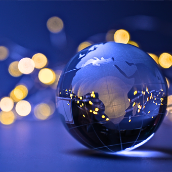 A glass globe reflecting warm lights, with a blurred background of glowing bokeh