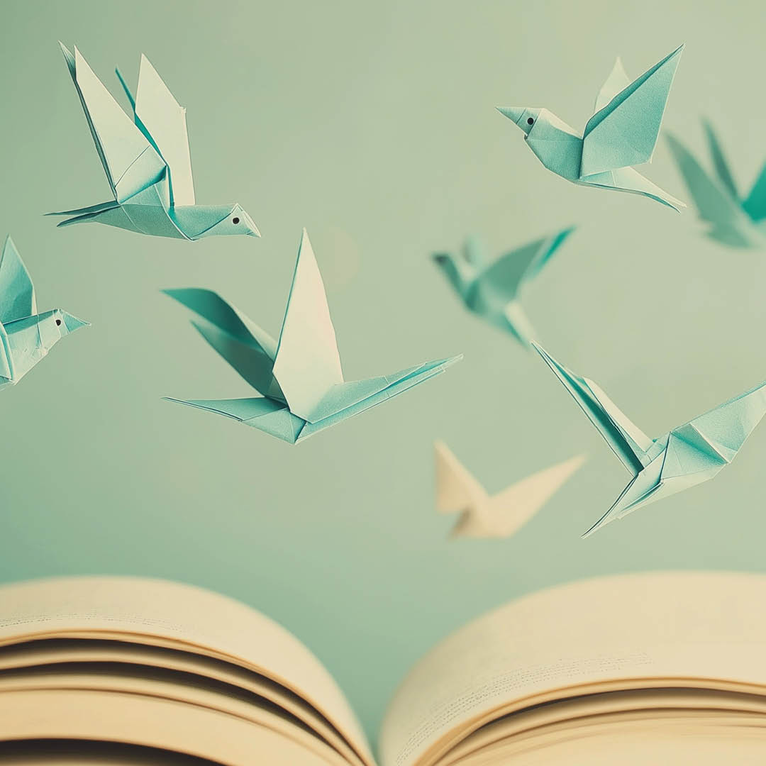 Origami di uccellini azzurri volano sulle pagine di un libro aperto
