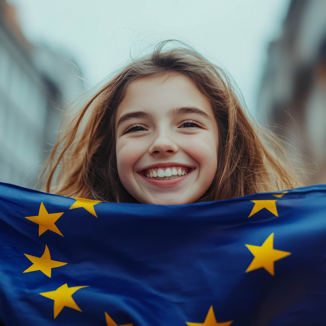 Bambina sorridente che tiene in mano bandiera UE