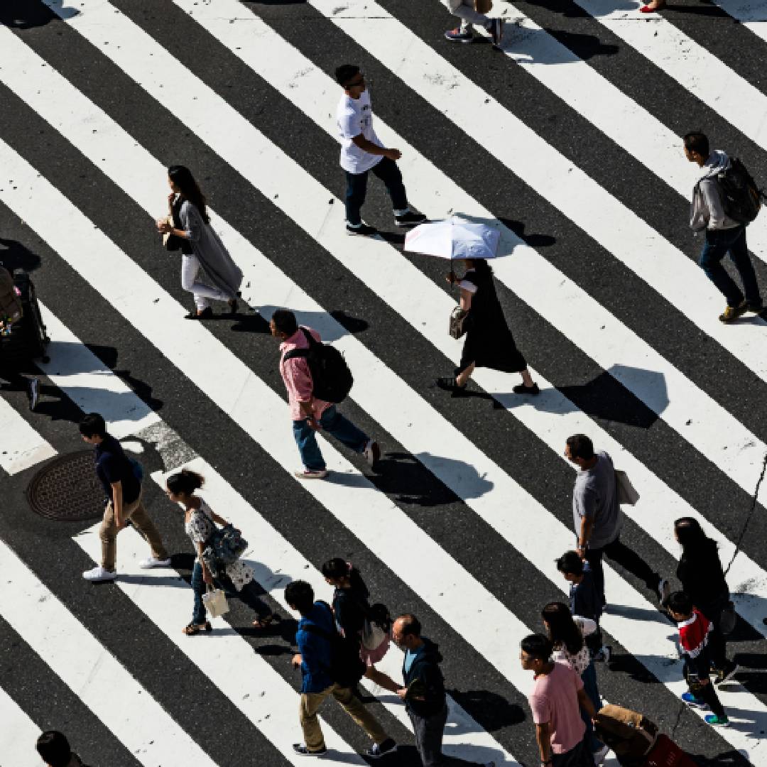 Persone che camminano in diverse direzioni su strisce pedonali