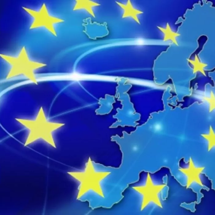 L’immagine mostra una mappa stilizzata dell’Europa in tonalità di blu, con grandi stelle gialle sovrapposte, tipiche della bandiera dell’Unione Europea. Sono presenti anche linee luminose che simboleggiano collegamenti o interconnessioni tra i paesi.