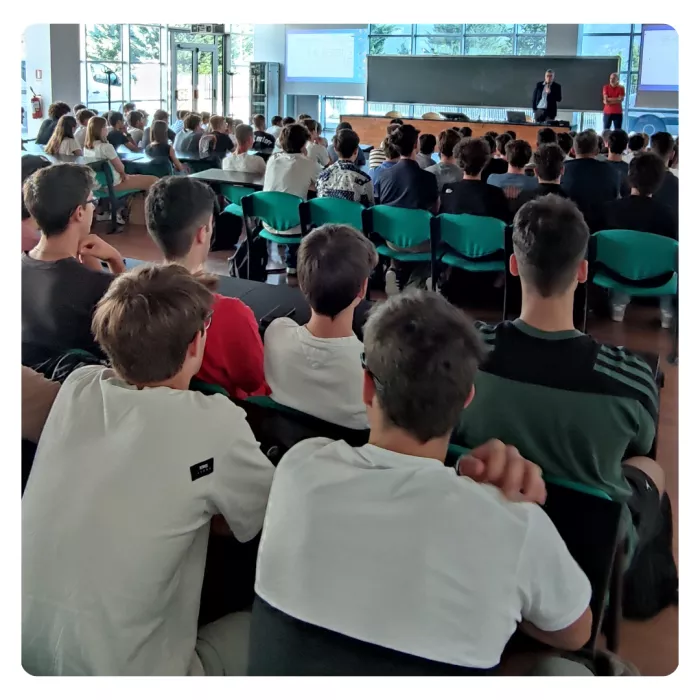 Studenti e studentesse di spalle seguono un seminario