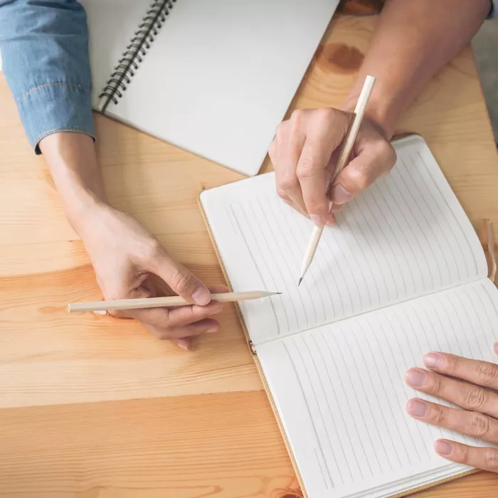 Mani che scrivono su un quaderno