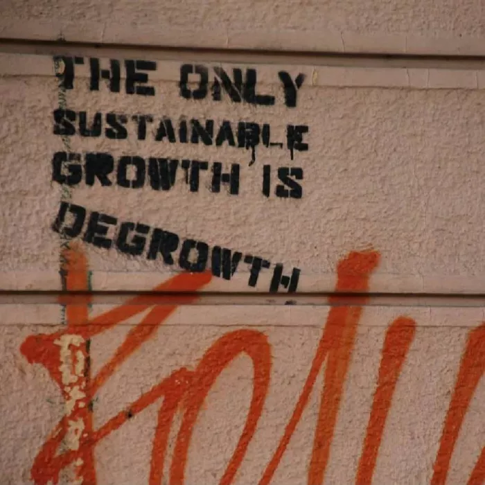 Scritta su muro sulla crescita/decrescita